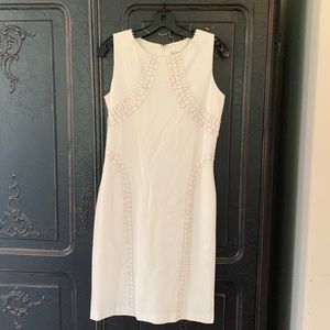 Clunky white dress with leather features.